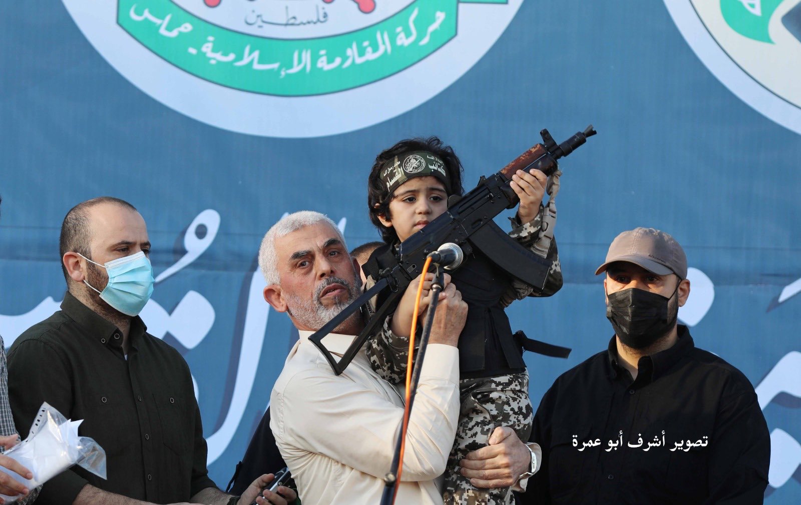 Yahya Sinwar holding a boy with a gun in his hand